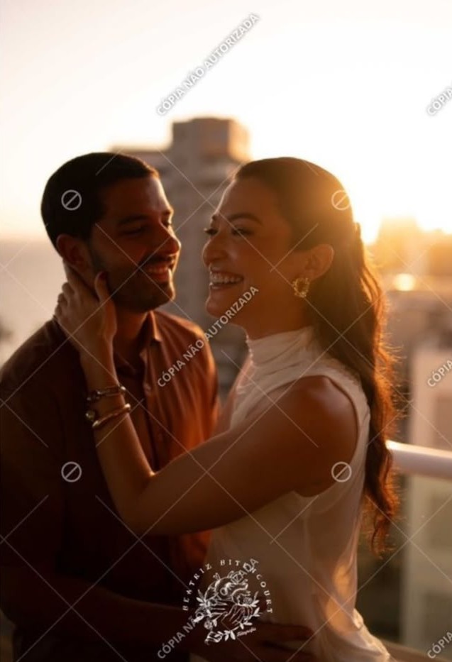 Júlia e Caio sorrindo um para o outro