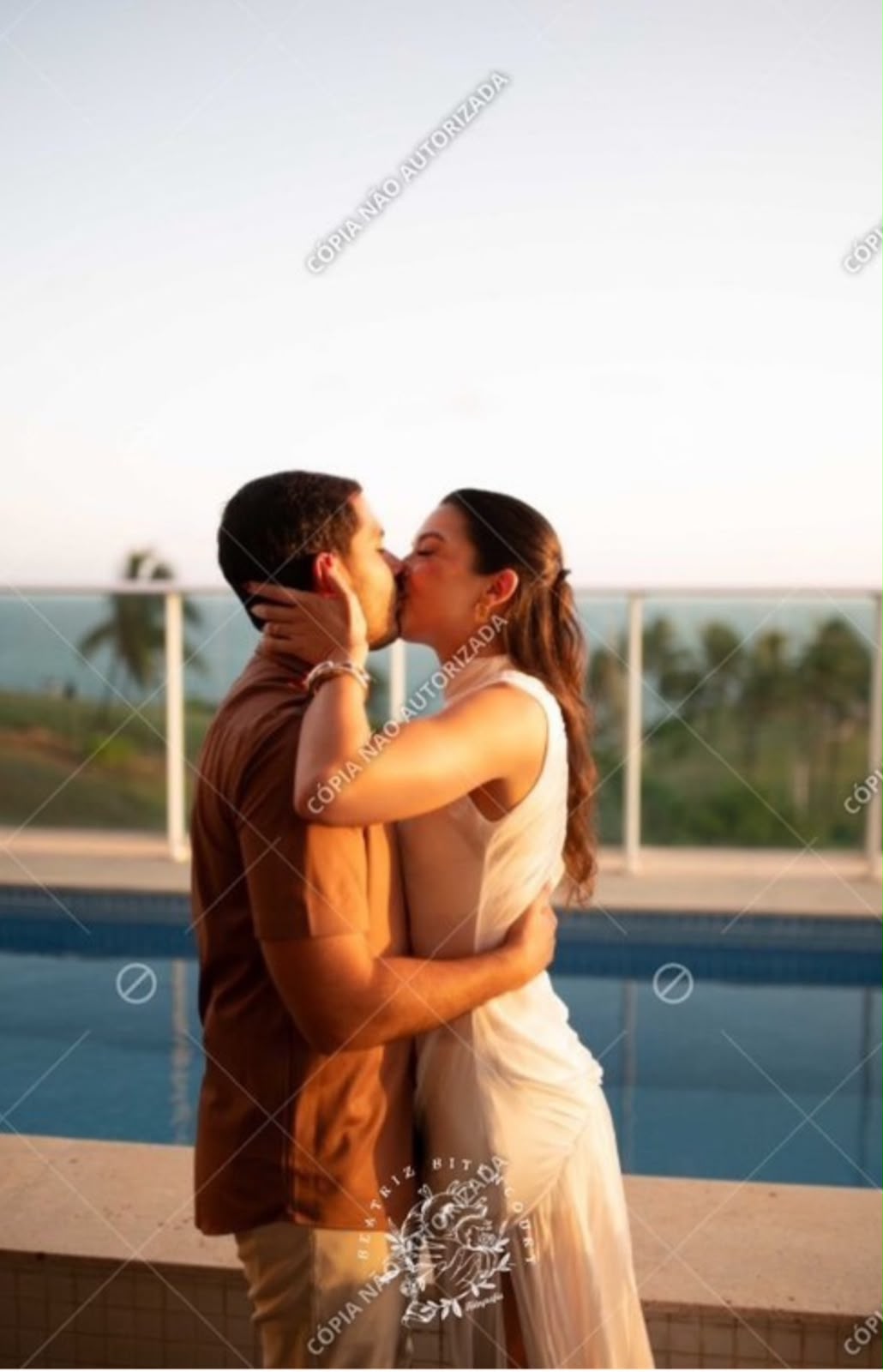 Júlia e Caio se beijando ao pôr do sol